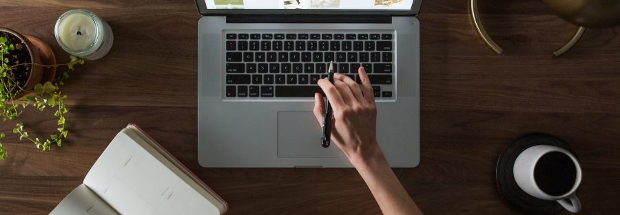 persoon werkt aan laptop aan nieuwe website met koffie